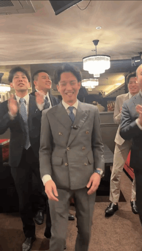 A Group Of Men In Suits Are Dancing Together GIF