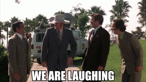 A Group Of Men In Suits Are Laughing In Front Of A Van With The Number 9 On The Back GIF