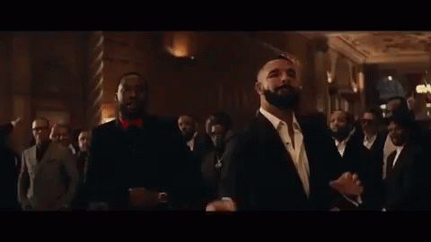 A Group Of Men In Suits Are Standing Next To Each Other In A Room . GIF