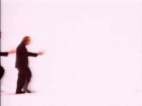 A Group Of Men In Suits Are Walking In A Row . GIF