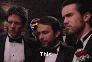 A Group Of Men In Tuxedos And Bow Ties Are Standing Next To Each Other In A Bar . GIF