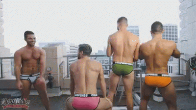 A Group Of Men In Underwear Are Dancing On A Rooftop GIF