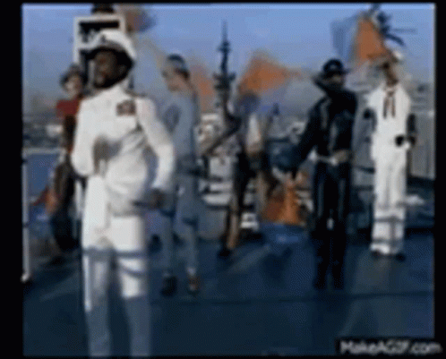 A Group Of Men In White Military Uniforms Are Standing On A Boat . GIF
