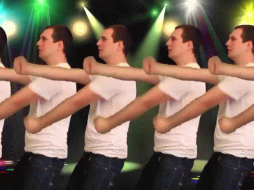 a group of men in white shirts are dancing in a line