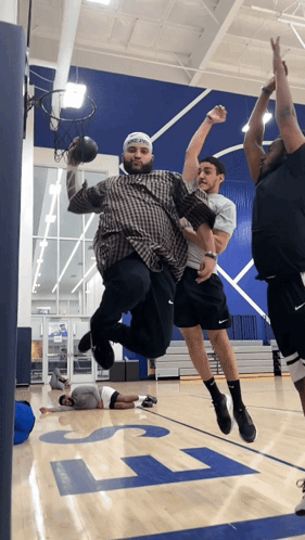 a group of men playing basketball on a court with the letter l on the floor