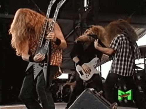A Group Of Men Playing Guitars On A Stage With A Green M On The Bottom Right GIF