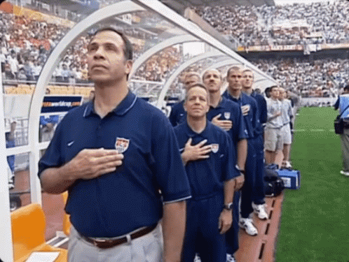 A Group Of Men Stand With Their Hands On Their Hearts GIF