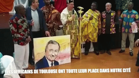 A Group Of Men Standing Around A Painting Of A Man With The Words Les Africains De Toulouse On The Bottom Right GIF