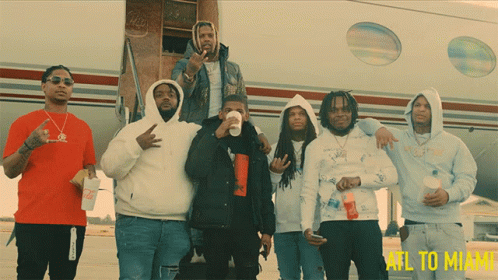 A Group Of Men Standing In Front Of An Airplane That Says Atl To Miami On The Bottom GIF
