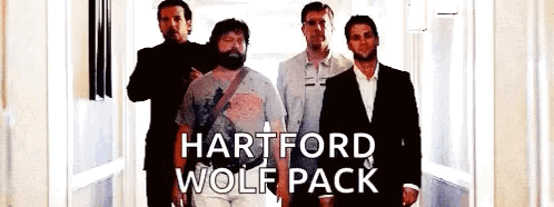 a group of men standing next to each other in a hallway with the words hartford wolf pack on the bottom .