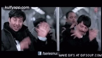 A Group Of Men Standing Next To Each Other On A Train . GIF