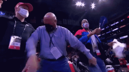 A Group Of Men Wearing Face Masks Are Standing In A Stadium . GIF