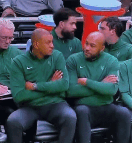 A Group Of Men Wearing Green Nike Sweatshirts Sit In A Stadium GIF