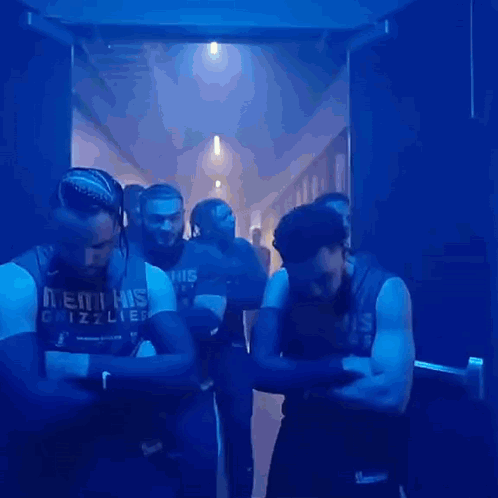 A Group Of Men Wearing Memphis Grizzlies Jerseys Are Standing In A Hallway GIF