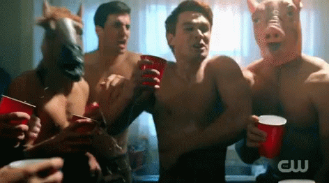 A Group Of Men Wearing Pig Masks And Horse Masks Holding Red Cups GIF