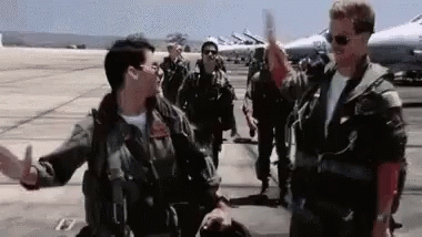 A Group Of Military Men Are Standing On A Runway Giving Each Other A High Five . GIF