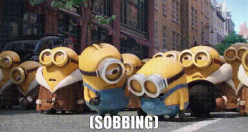 A Group Of Minions Are Standing In A Line On A City Street . GIF