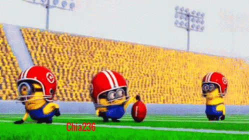 A Group Of Minions Wearing Helmets And Goggles Are Playing Football On A Field GIF