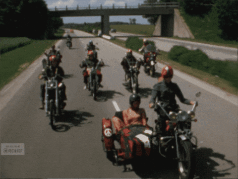 A Group Of Motorcycle Riders Are Riding Down A Highway GIF