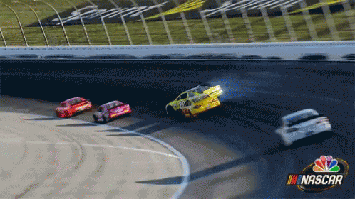 A Group Of Nascar Cars Are Racing Around A Track GIF