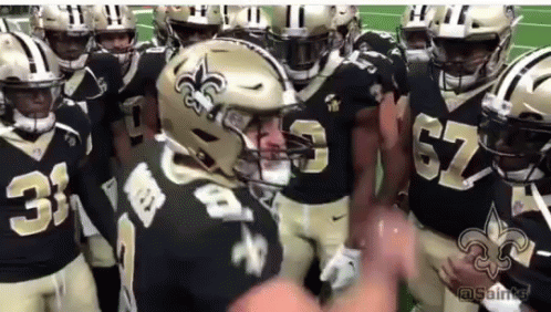 A Group Of New Orleans Saints Football Players Huddled Together GIF