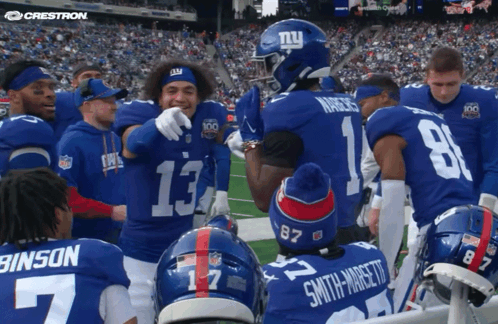 A Group Of New York Giants Players Huddle On The Field GIF