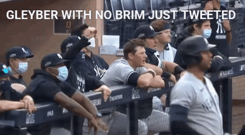 A Group Of New York Yankees Baseball Players Wearing Face Masks In A Dugout GIF