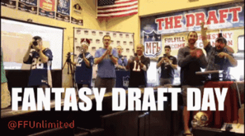 A Group Of People Applauding In Front Of A Sign That Says The Draft Fantasy Draft Day GIF