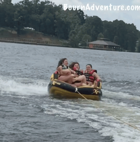 A Group Of People Are Being Towed By A Boat With The Website Tournadventure.com Visible In The Background GIF