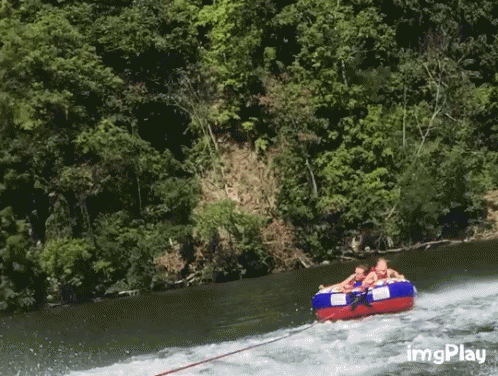 A Group Of People Are Being Towed Down A River By A Boat With Imgplay In The Corner GIF