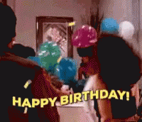 A Group Of People Are Celebrating A Birthday With Balloons And Confetti GIF