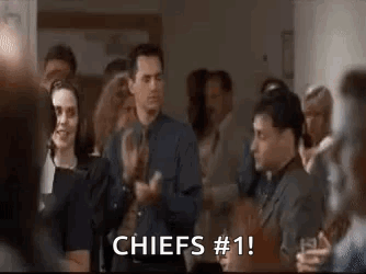 A Group Of People Are Clapping In A Room And A Man Is Saying `` Chiefs # 1 '' . GIF