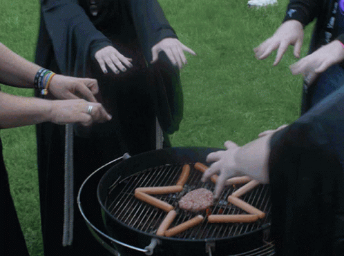 A Group Of People Are Cooking Hot Dogs And A Hamburger On A Grill In The Shape Of A Pentagram GIF