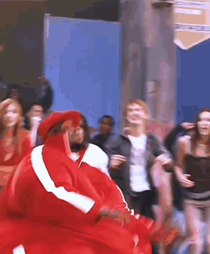 A Group Of People Are Dancing And One Of Them Is Wearing A Red Jacket GIF