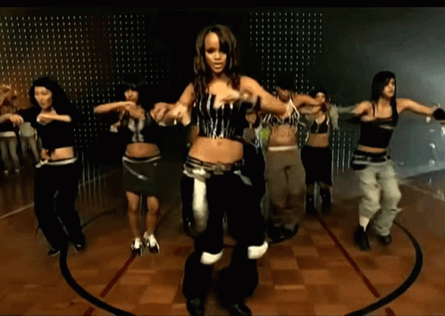 A Group Of People Are Dancing In A Circle On A Wooden Floor GIF