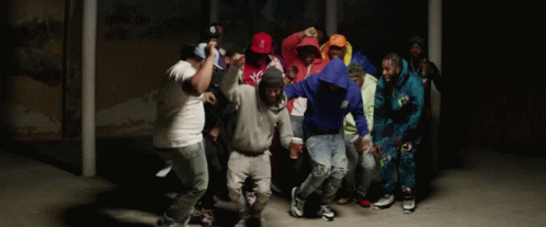 A Group Of People Are Dancing In A Dark Room And One Of Them Is Wearing A Hoodie That Says ' A ' GIF