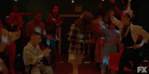 A Group Of People Are Dancing In A Dark Room In Front Of An Fx Logo . GIF