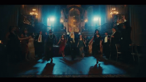 A Group Of People Are Dancing In A Dark Room With Candles . GIF