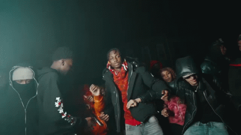 A Group Of People Are Dancing In A Dark Room With Purple Lights GIF