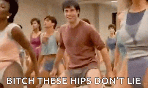A Group Of People Are Dancing In A Gym And A Man Is Holding His Pants Up . GIF