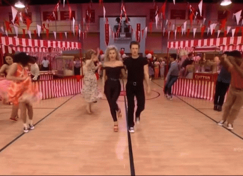 A Group Of People Are Dancing In A Gym With Cotton Candy Stands In The Background GIF