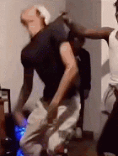 A Group Of People Are Dancing In A Living Room . GIF