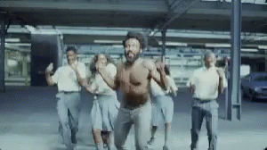 A Group Of People Are Dancing In A Parking Lot . GIF