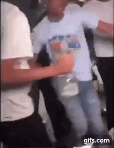 A Group Of People Are Dancing In A Room While A Man Is Holding A Bottle Of Water . GIF