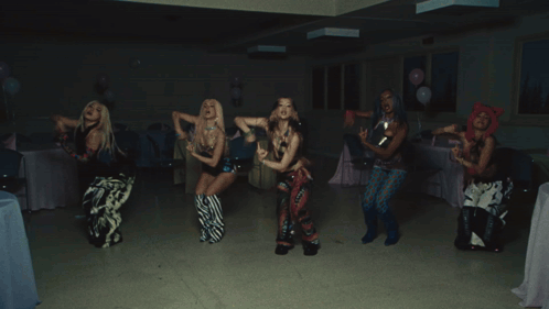 A Group Of People Are Dancing In A Room With A Blue Bag That Says Hawaii GIF