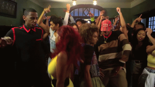 A Group Of People Are Dancing In A Room With A Man Wearing A Hat That Says 1994 GIF