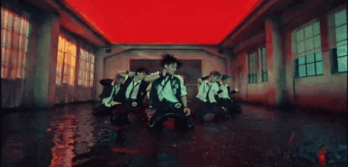 A Group Of People Are Dancing In A Room With A Red Ceiling . GIF
