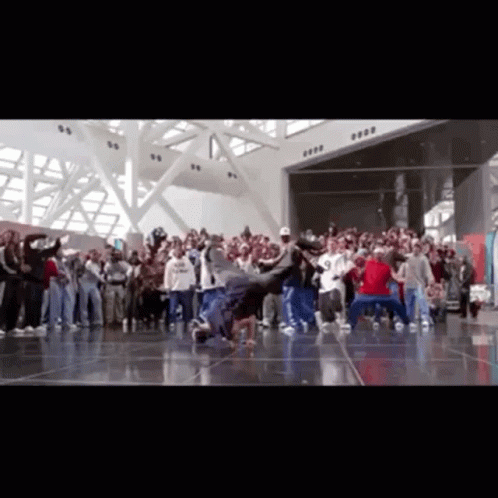 A Group Of People Are Dancing In A Room With A Sign That Says ' 8888 ' On It GIF