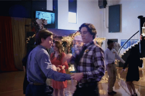 a group of people are dancing in a room with a sign that says safety