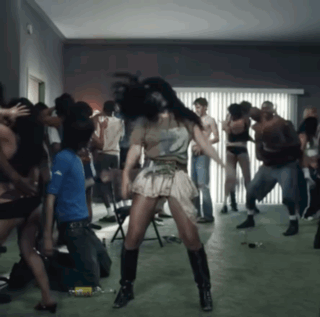 A Group Of People Are Dancing In A Room With A Woman Wearing A Number 2 Shirt On GIF